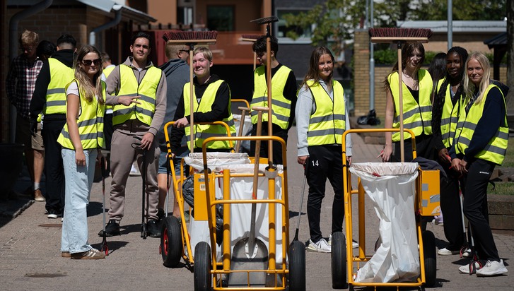 En grupp människor i gula västar som står runt en vagn.