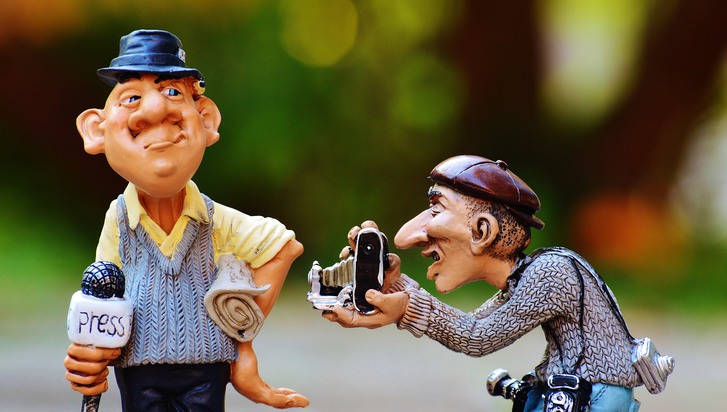Två keramikfigurer som föreställer en reporter och en fotograf.