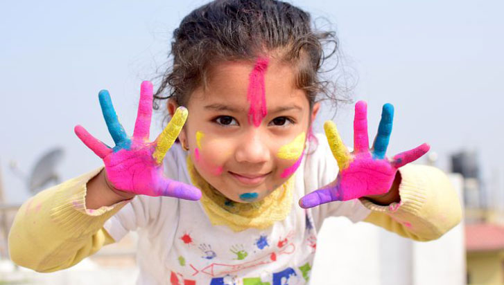 Barn med fingerfärg på händerna