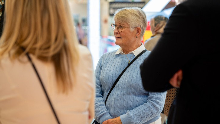 En grupp människor som står och pratar med varandra.