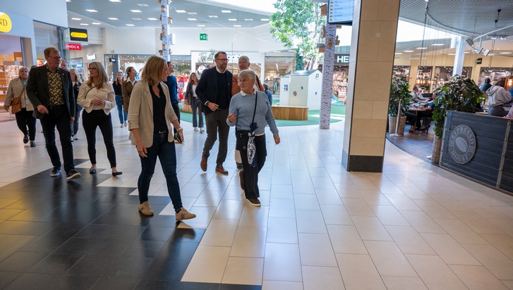 En grupp människor som går genom ett köpcentrum.