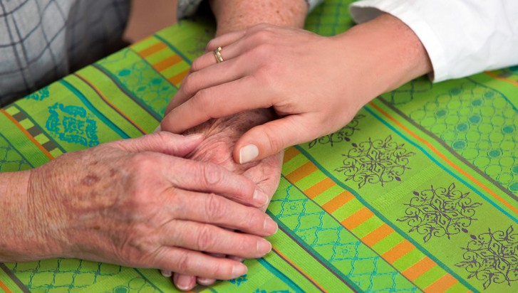 Yngre hand ger omsorg till äldre händer