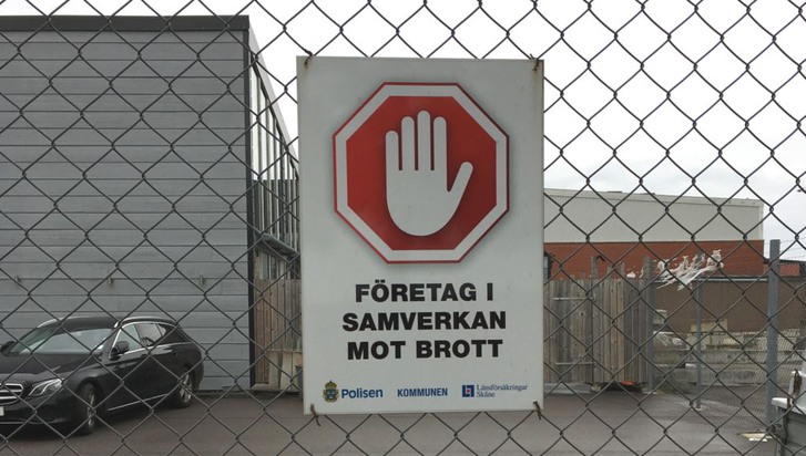 skylt på staket med en handflata och en text som säger: "företag i samverkan mot brott"