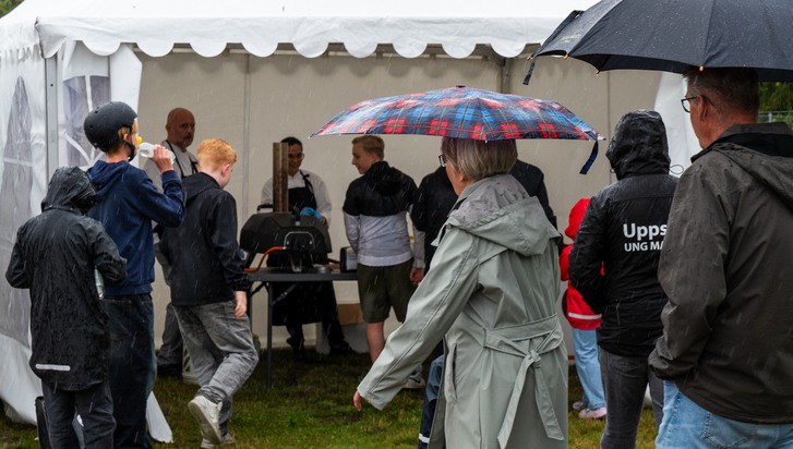 En grupp människor som står runt ett tält.