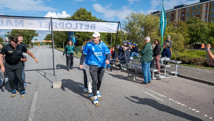 En grupp människor som går med skidor längs en gata.