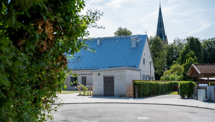 Ett litet vitt hus med blått tak.