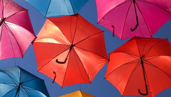 paraplyer i många olika färger mot en blå bakgrund