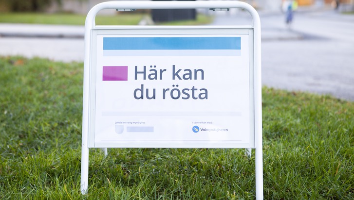 En skylt som sitter i gräset.