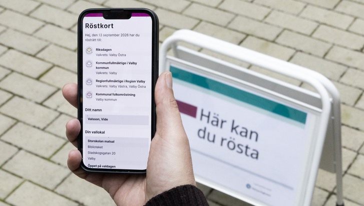 En person som håller en mobiltelefon i handen.