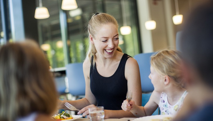 kvinnlig lärare äter måltid med barn