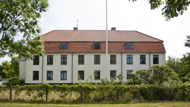 En stor vit byggnad med en flagga på toppen
